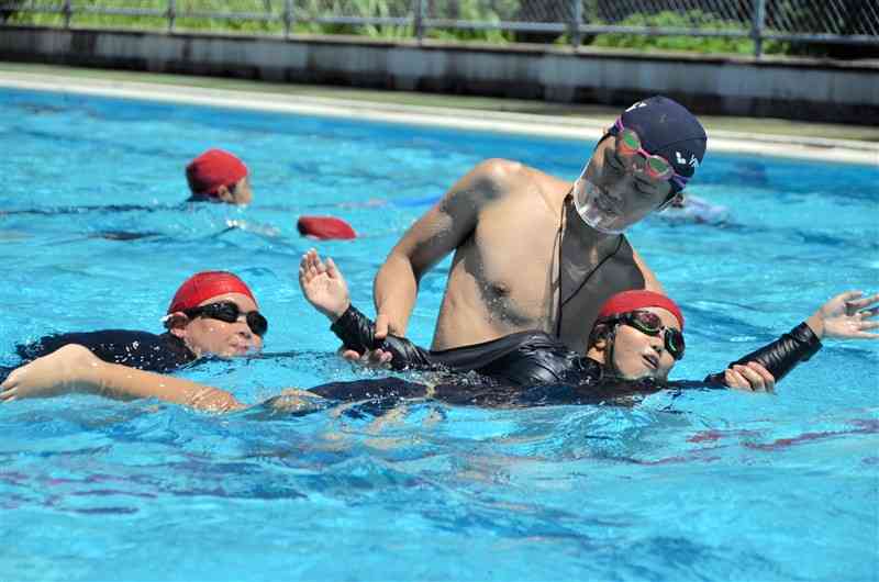 熊本YMCAの指導者から、クロールの泳ぎ方を学ぶ津森小の児童ら＝益城町