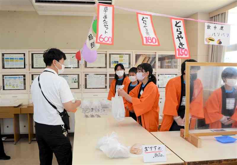 「江原中マーケット」で商品を手渡す生徒ら＝熊本市中央区