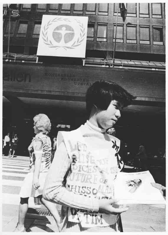 国連人間環境会議の会場前で、英文のビラを配る坂本しのぶさん。同行した写真家の塩田武史さん（故人）が撮影した＝1972年6月、ストックホルム（妻の塩田弘美さん提供）