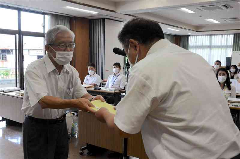 論語のテキストを境敬一郎校長会長（右）に贈呈する坂本敏正会長＝菊池市