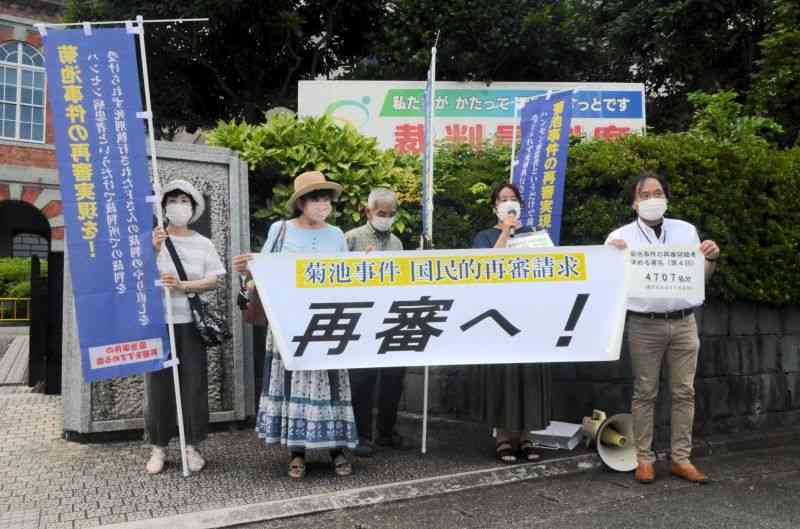 菊池事件の再審開始を求める署名の提出を前に、熊本地裁前で集会を開く弁護士や支援者ら＝8日、熊本市中央区