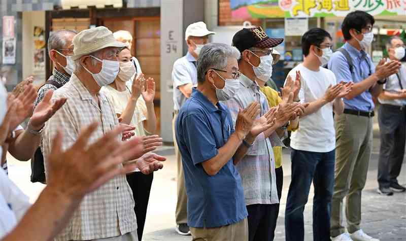 候補者の街頭演説を聞き、拍手する支持者ら＝9日午後、熊本市（石本智）