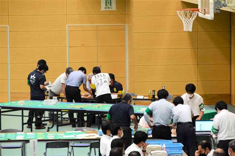 参院選の開票作業で疑問票を精査する天草市職員ら＝11日午前0時過ぎ、同市