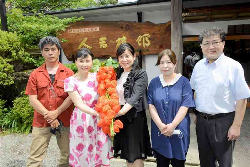 生産者の浦上徹さん（左端）から贈られたホオズキを持つ人吉温泉旅館組合の女将ら＝人吉市