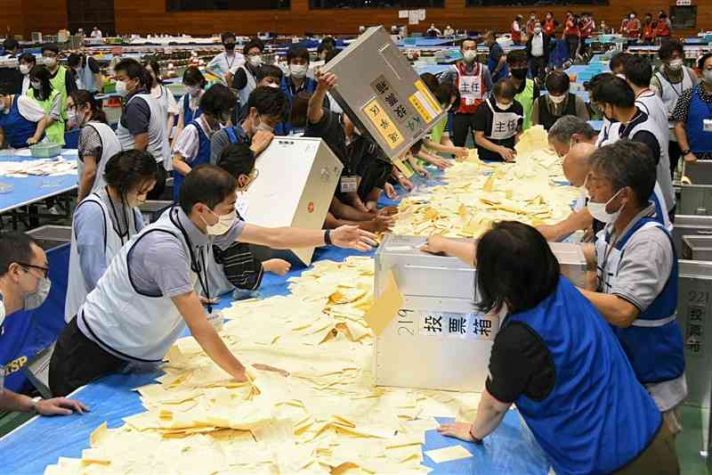 参院選の開票作業を一斉に始める熊本市の職員ら＝10日午後9時20分過ぎ、中央区の市総合体育館（大田垣典子）