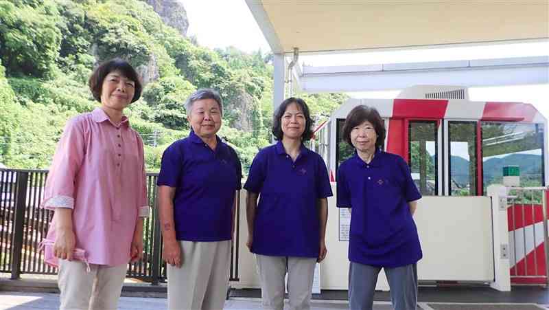 モノレール前に並ぶ津奈木町地域婦人会の会員。運行のほか、観光案内を担うことも＝同町