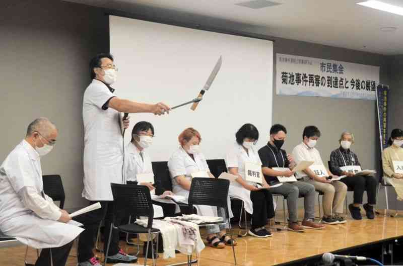 「特別法廷」を再現した朗読劇。検察官が凶器とされた短刀をトングで扱う場面もあった＝16日、熊本市中央区