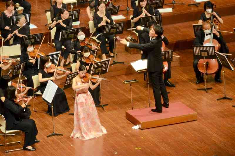 伸びやかな演奏を披露する出演者。バイオリンのソリストは柴田恵奈さん、指揮は神成大輝さん＝熊本市中央区