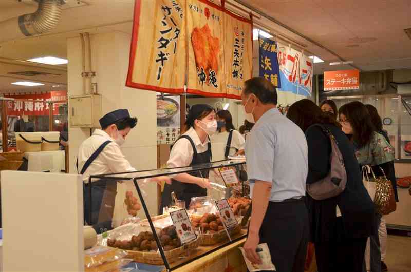 鶴屋百貨店で始まった「おきなわフェア」で品定めする買い物客＝20日、熊本市中央区