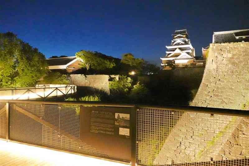 夜間開園が始まり、石垣や特別見学用の通路がライトアップされた熊本城＝22日夜、熊本市中央区