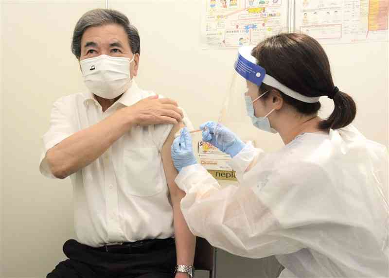 4回目のワクチン接種を受ける蒲島郁夫知事（左）＝23日、熊本市中央区
