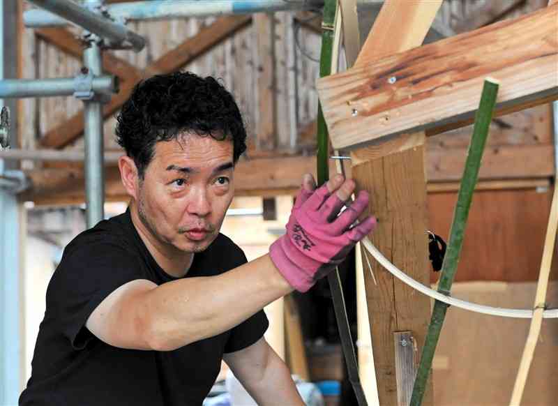 真剣な表情で大造り物の制作を進める下市連合組の橋本浩彰さん＝山都町