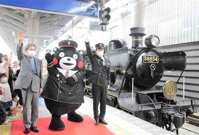 駅長の制服姿でSL人吉出発の号令をかけるくまモン＝31日、熊本市西区