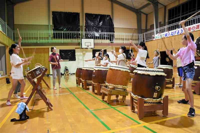 旧月瀬小の体育館で源九郎太鼓の練習をする子どもたち＝玉名市