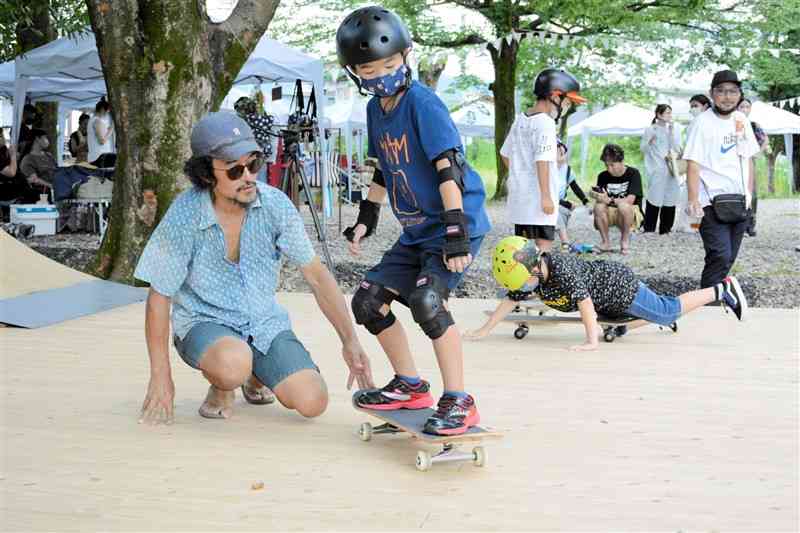 スケートボードパーク「くまびば」でスケボーを体験する子ども＝人吉市