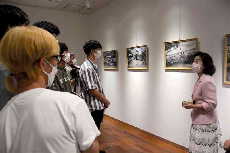 旅館が被災した当時の状況を学生たちに話す「清流山水花あゆの里」の有村政代さん（右）＝人吉市