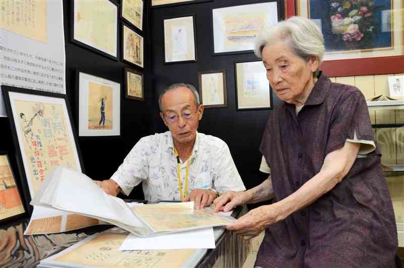 笠秀雄さんが残した作品を見るおいの昭二さん（左）と上田敦子さん＝菊池市