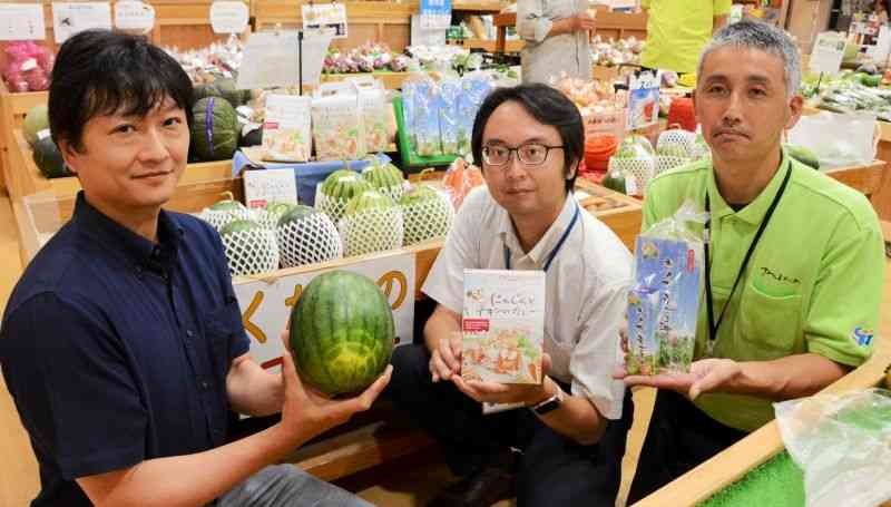 ふるさと納税の返礼品を手にする菊陽町の担当者ら＝同町