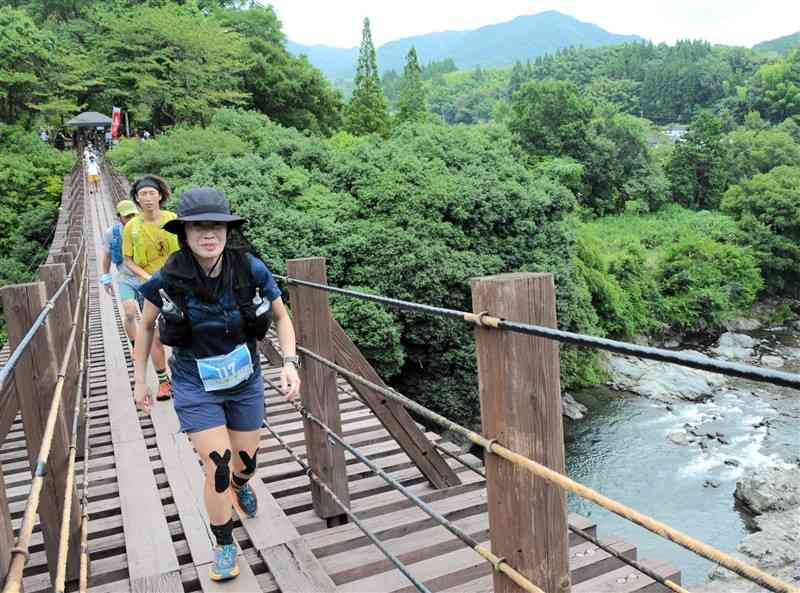 つり橋の上を駆け抜けるランナーたち＝氷川町