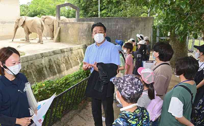 熊日の岩下勉デジタル編集部長（中央）から熊本地震の被災状況などの説明を受ける子どもたち。左は熊本市動植物園の獣医師・上野明日香さん＝12日午前、熊本市東区の同園（横井誠）