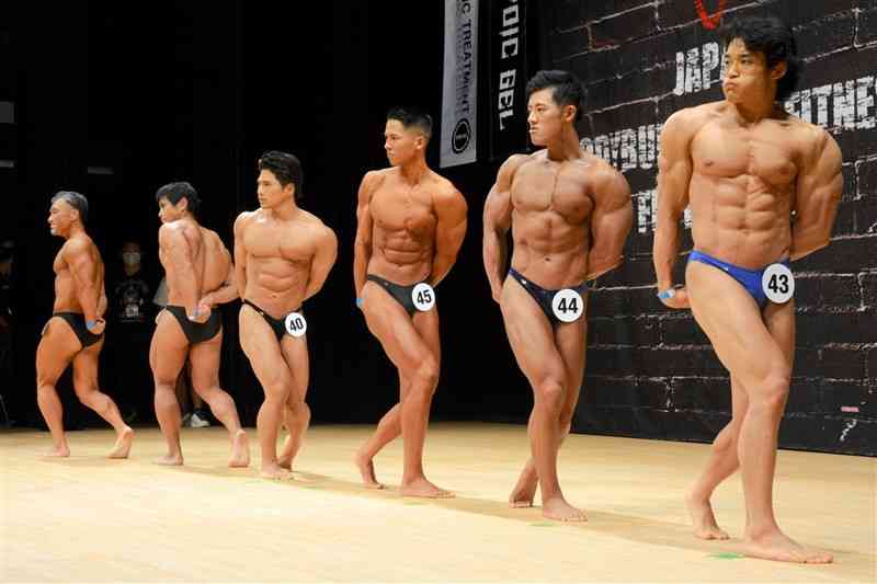 トレーニングで鍛え抜いた筋肉を披露する選手ら＝熊本市西区