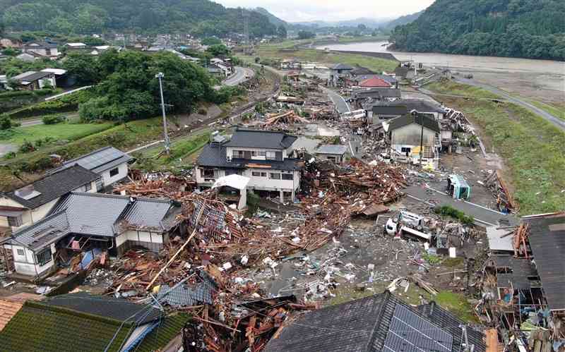 2020年7月豪雨で甚大な被害が出た球磨川（右上）沿いの集落。この豪雨災害に伴う熊本県内の保険金支払額は約430億円に上った＝2020年7月、球磨村（小型無人機で撮影）