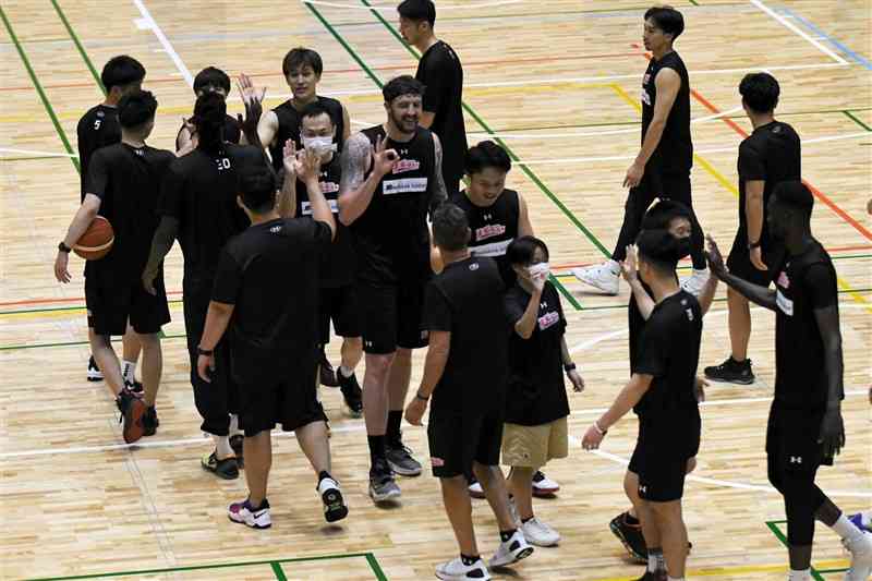 練習終了後、ハイタッチする熊本ヴォルターズの選手やスタッフら＝益城町総合体育館