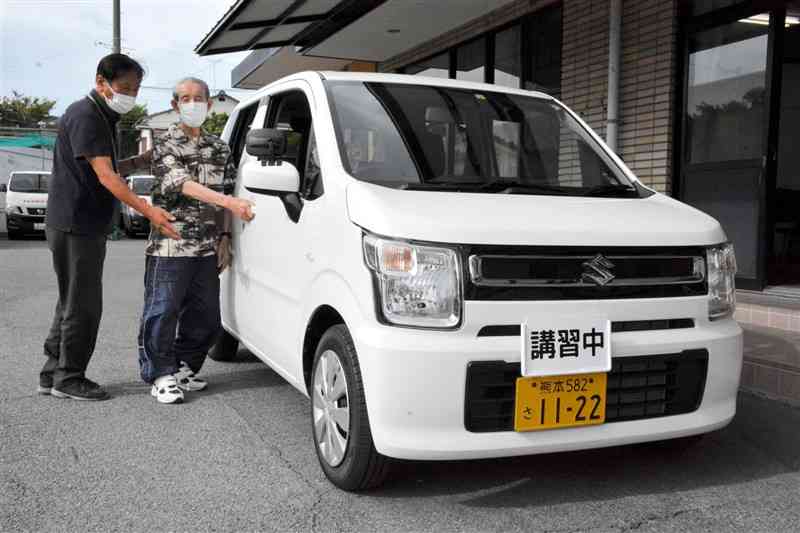 高齢者講習で軽乗用車に乗り込む受講生と教官＝16日、熊本市中央区