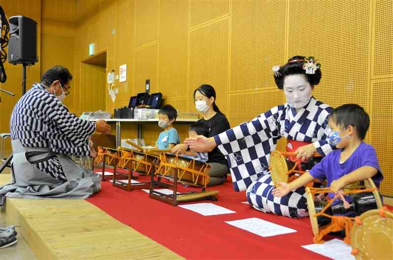 「夏休み伝統芸能ワークショップ」で、鳴物を体験する子どもたち＝熊本市中央区