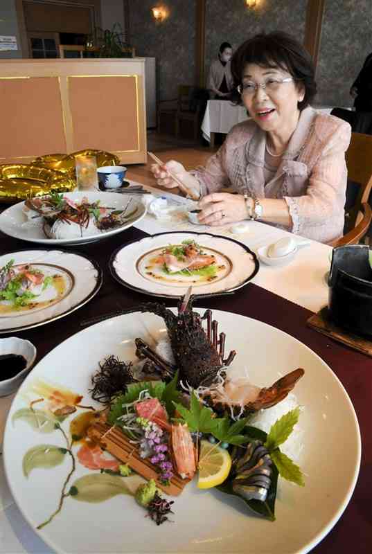 「天草伊勢えび祭り」で提供される料理を試食する女性＝天草市