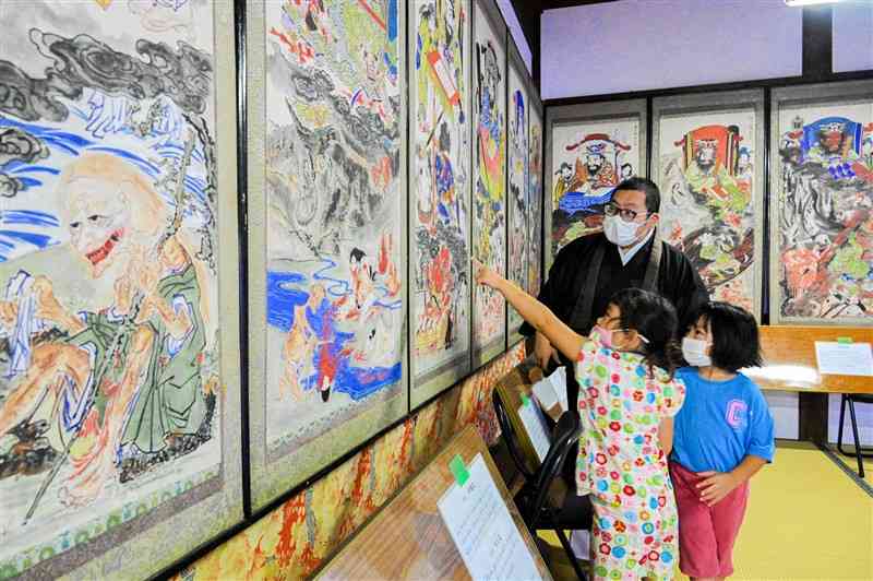 円応寺の地獄極楽絵図を見入る子どもたち＝宇土市