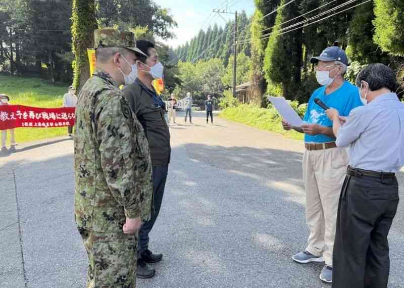 大矢野原演習場で始まった日米共同軍事演習に反対する抗議文を読み上げる山都町民の会のメンバー（右）＝28日、同町