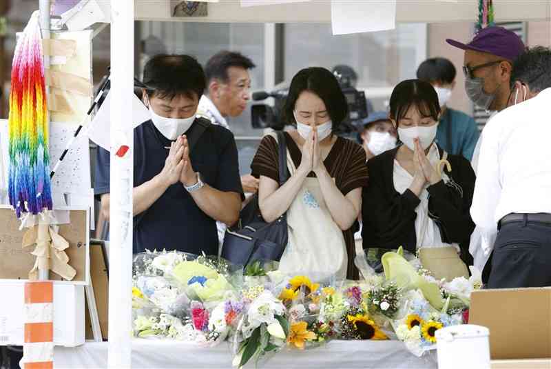 7月中旬、安倍元首相が銃撃された奈良市の現場近くの献花台で、手を合わせる人たち