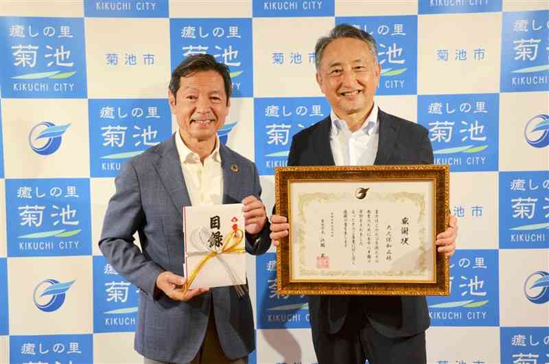 菊池市に寄付した日本電子材料の大久保和正社長（右）と江頭実市長＝同市