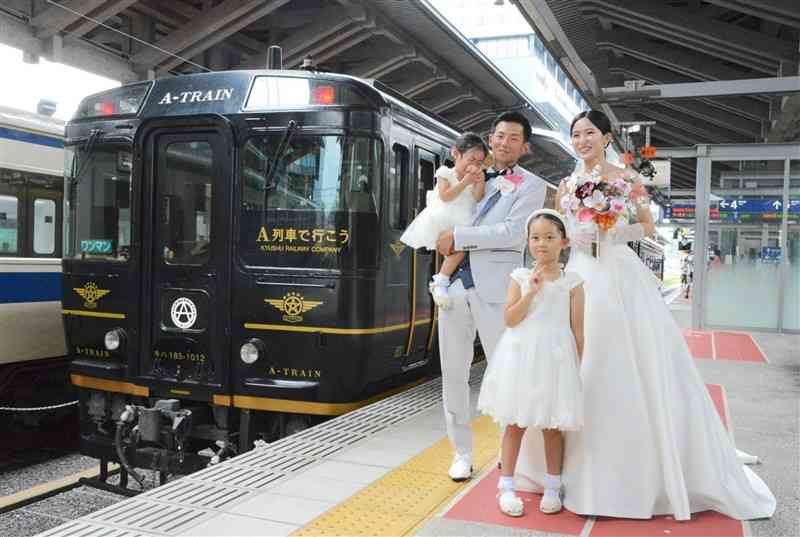 観光列車「A列車で行こう」で結婚式を挙げた生駒潤さん、涼杏さん夫婦＝3日、熊本市西区の熊本駅