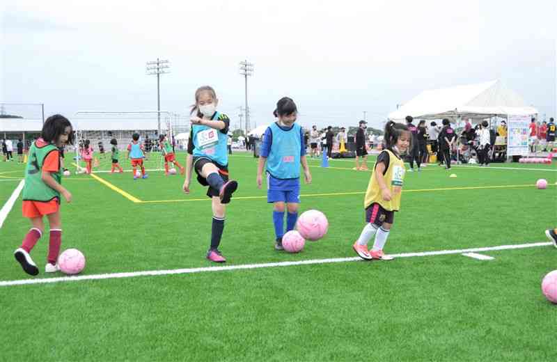 県フットボールセンターの開設イベントでサッカーを楽しむ子どもたち＝3日、嘉島町