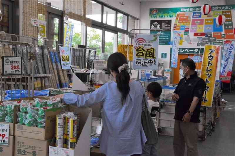 台風対策の商品を置く特設コーナーで商品を選ぶ買い物客＝4日、熊本市西区