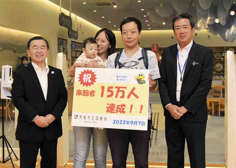 15万人目の来館者となった後藤拓也さん（右から2番目）、真美子さん（同3人目）、利希ちゃん＝荒尾市