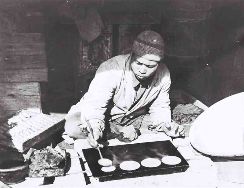 店で販売するための菓子を作っている澤田さん＝1936年2月、覚井