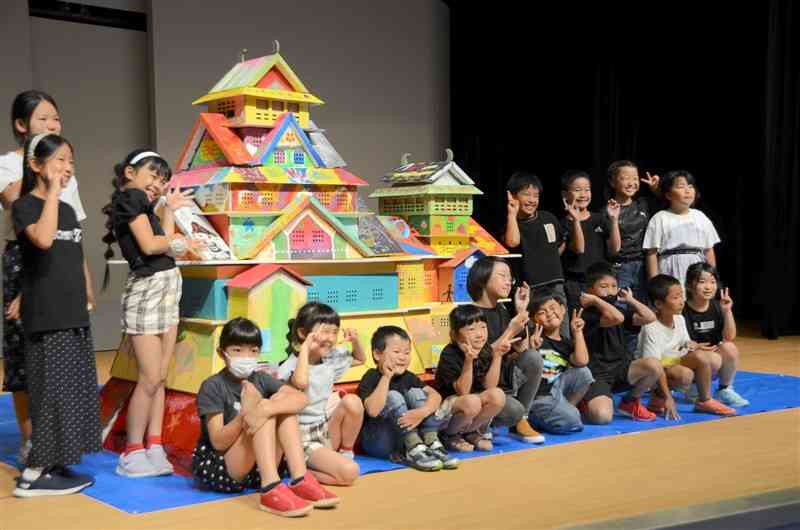 完成した色とりどりの熊本城と記念写真に納まる子どもたち＝熊本市中央区