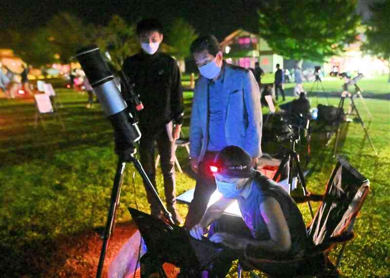 望遠鏡とパソコンを使って天体観察する参加者＝産山村