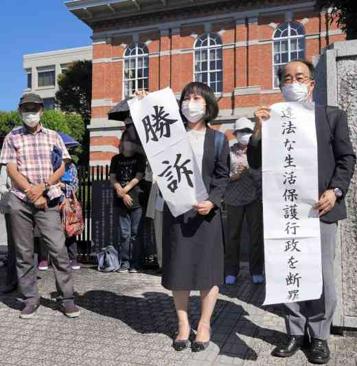 熊本地裁の判決後、「勝訴」の紙を掲げる髙木百合香弁護士＝3日午後、熊本市中央区