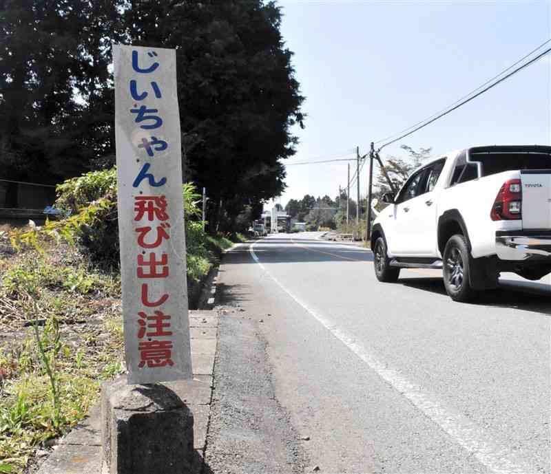 ミルクロードの道沿いにある「じいちゃん飛び出し注意」の看板＝大津町