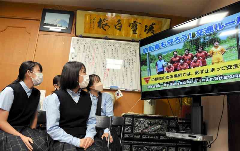 県警が制作した交通安全の啓発動画を見る玉名女子高サッカー部員＝玉名市