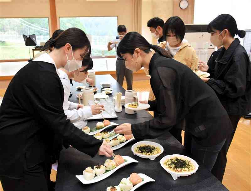 試作品のおにぎりとライスピザを試食する尚絅大生＝湯前町