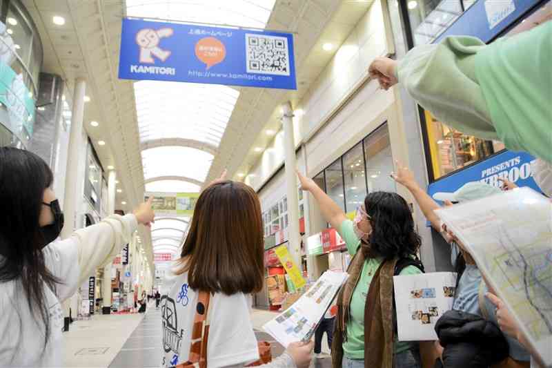 「ロゲイニング」で上通商店街内のチェックポイントを巡る留学生ら＝熊本市中央区