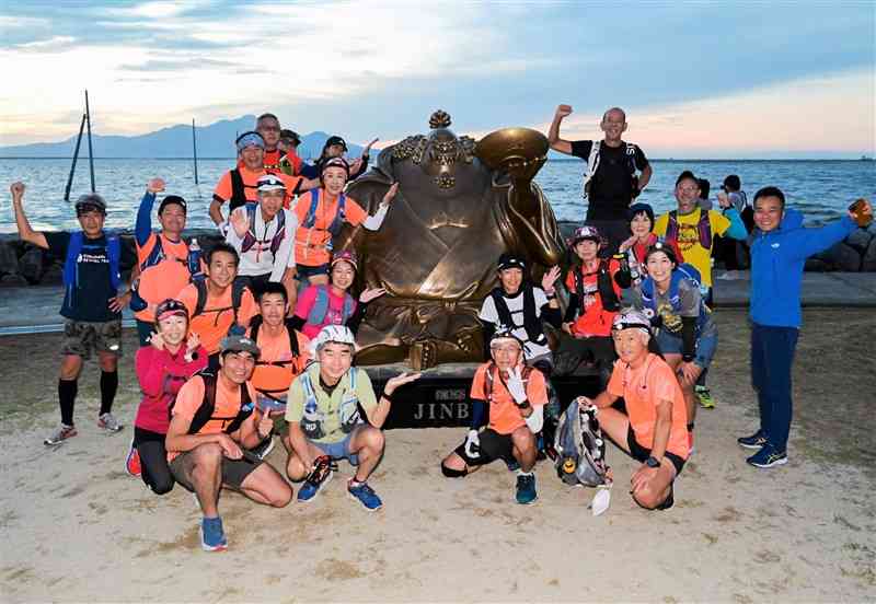 ジンベエ像のある住吉海岸公園をスタートする「熊本てれっとウルトラマラソンクラブ」のメンバー＝宇土市