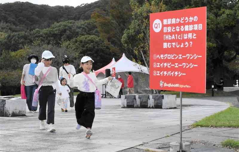 健康クイズラリーでチェックポイントを目指す参加者＝熊本市