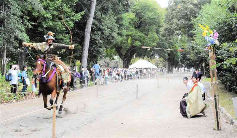 出水神社の秋季例大祭で、馬上から的に向けて矢を放つ射手＝熊本市中央区