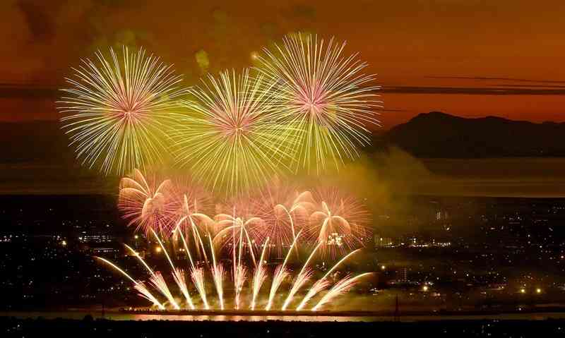 あかね色の空を背景に打ち上げられた「やつしろ全国花火競技大会」の花火＝10月15日夜、八代市の龍峰山から撮影（石本智）